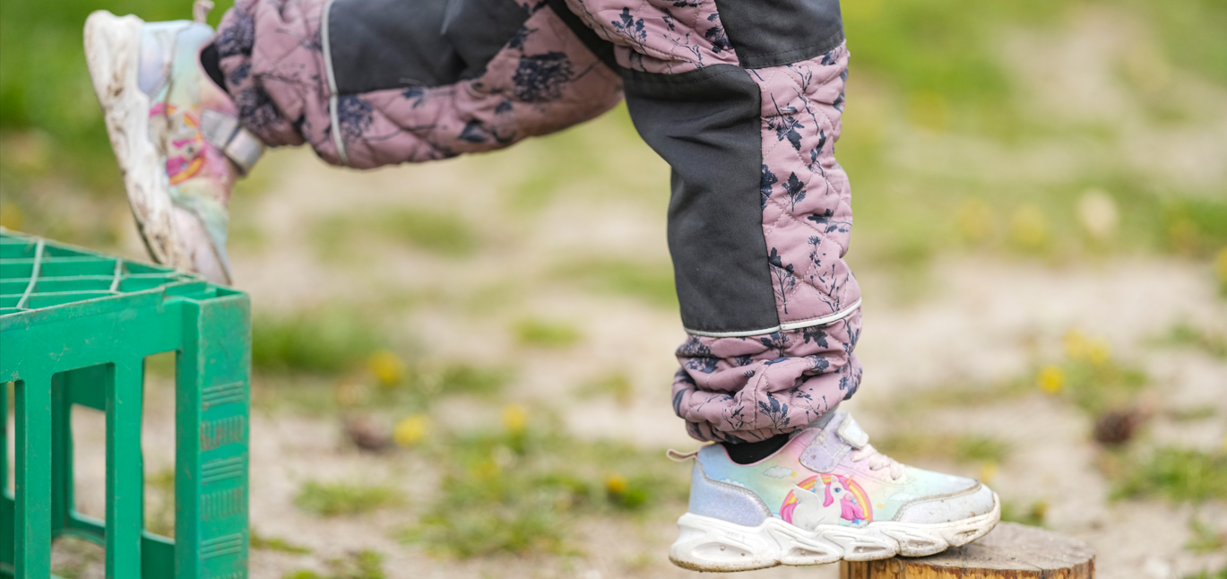 et barn balancer mellem to genstande 